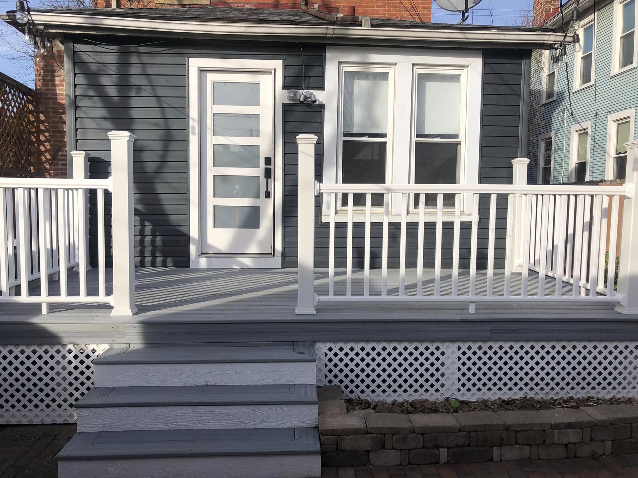 After: new composite deck, white vinyl railing, new door and windows, repainted siding