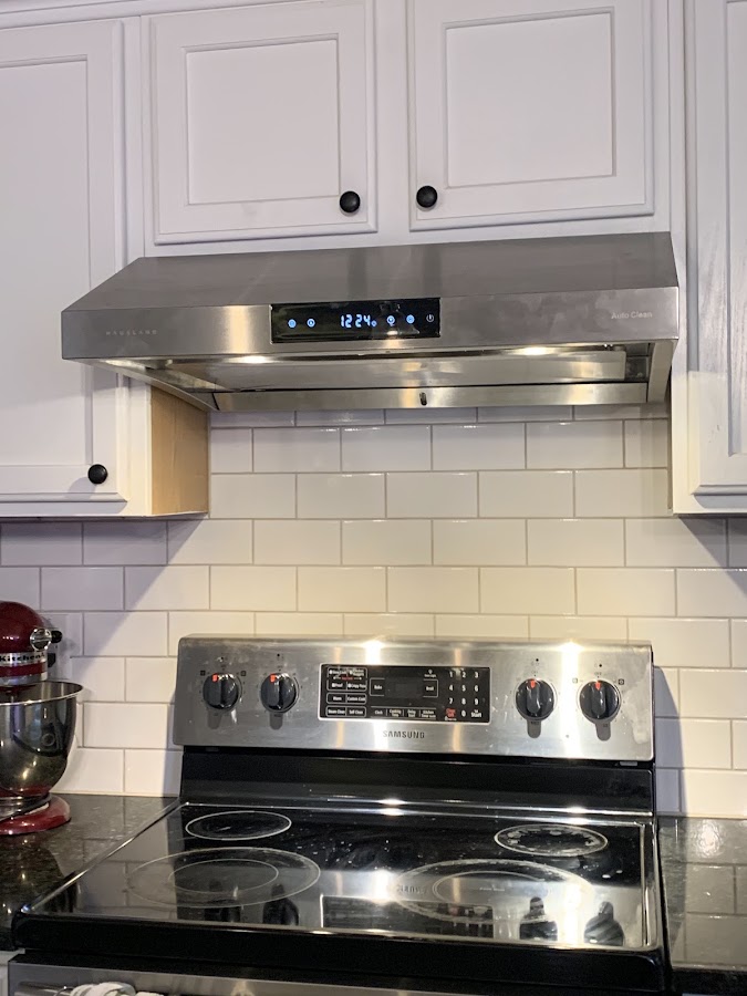 A finished kitchen remodel with new range hood and subway tile backsplash