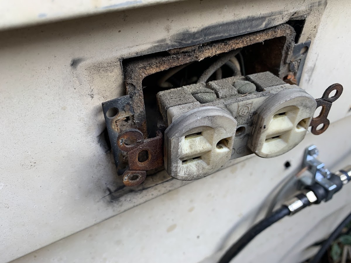 A damaged exterior outlet before repair